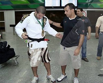 Rodolfo receiving his black belt at the airport.